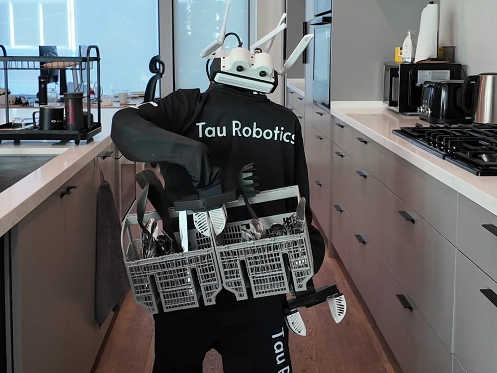 Humanoid unit holding a dishwasher cutlery basket in a kitchen